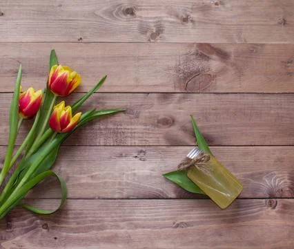 Spring Easter bouquet of tulip flowers with cosmetic product on wood background Stock Photos