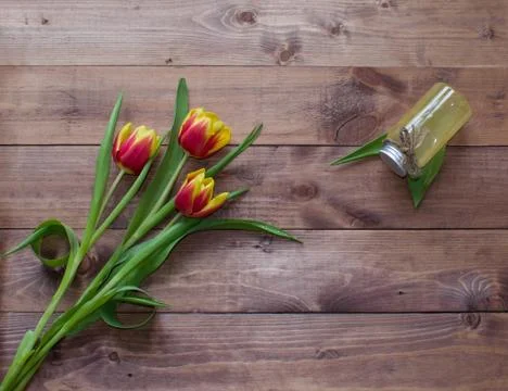 Spring Easter bouquet of tulip flowers with cosmetic product on wood background Stock Photos