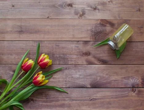Spring Easter bouquet of tulip flowers with cosmetic product on wood background Stock Photos