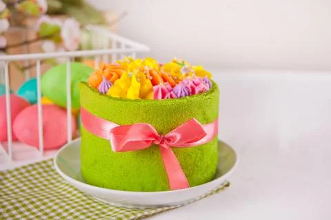Spring Easter festive table. Small green cake with butter cream flowers and c Stock Photos