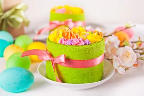 Spring Easter festive table. Small green cake with butter cream flowers and c Stock Photos