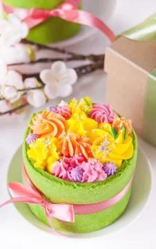 Spring Easter festive table. Small green cake with butter cream flowers and c Stock Photos