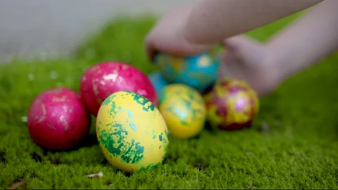 Spring egg hunt. little hands grabbing the colorful easter egg from the fresh gr Stock Footage 201043603