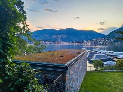 Spring evening view of Lake Lugano in the town of Caslano in the Swiss mountains Stock Photos