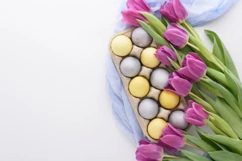 Spring festive Easter composition of eggs and purple tulips on white backgrou Stock Photos