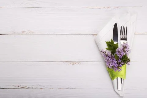 Spring festive table setting with vintage cutlery and lilac flowers on white Stock Photos