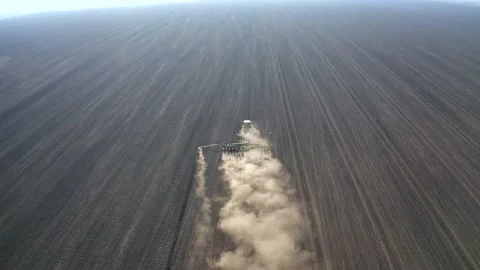 Spring field work, a tractor with a mounted seeder sow seeds in the ground Stock Footage 131033199
