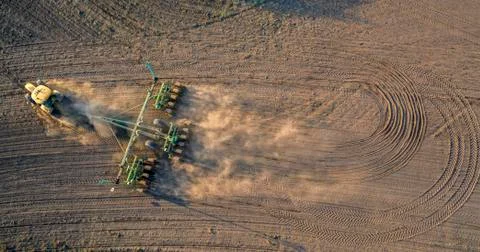 Spring field work, a tractor with a mounted seeder sow seeds in the ground Stock Photos