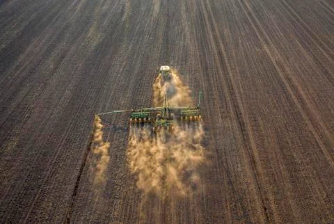 Spring field work, a tractor with a mounted seeder sow seeds in the ground Foto stock