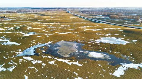 Spring fields aerial view. Snow melting, water pools on meadows. Season chang Stock Photos
