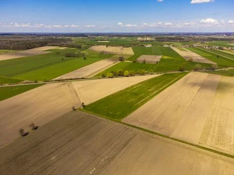 Spring fields, meadows and villages seen from a bird's eye view on a sunny, c Stock Photos