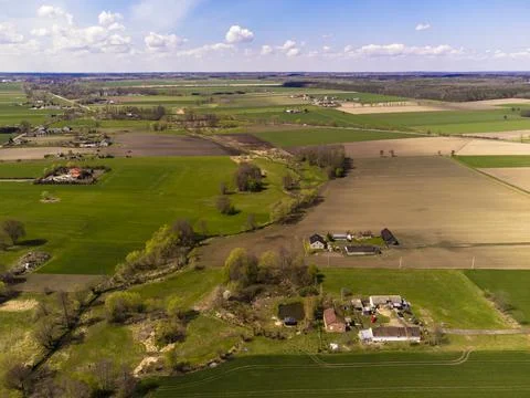 Spring fields, meadows and villages seen from a bird's eye view on a sunny, c Stock Photos