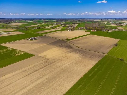Spring fields, meadows and villages seen from a bird's eye view on a sunny, c Stock Photos