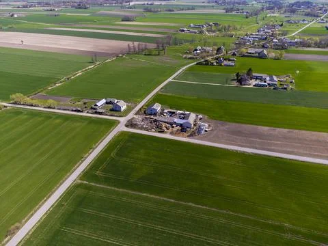Spring fields, meadows and villages seen from a bird's eye view on a sunny, c Stock Photos