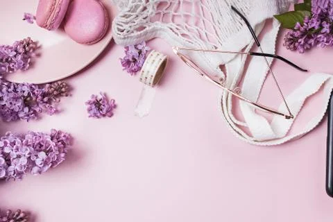 Spring flat lay with lilac flowers, glasses and macarons Stock Photos