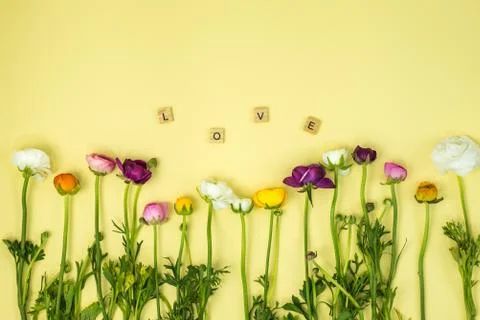 Spring flatlay concept background  with flowers and  love word on yellow backgro Foto stock