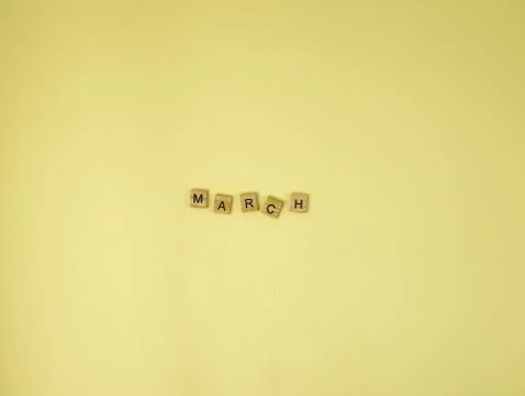 Spring flatlay concept background  with march wooden word on yellow background , Foto stock