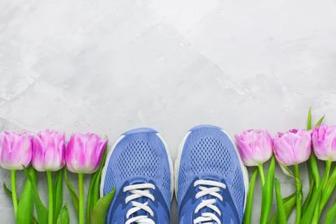 Spring flatlay sports composition with blue sneakers and purple tulips. Stock Photos
