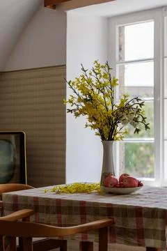Spring flower bouquet on rustic table beside bright window in vintage home. Stock-Fotos