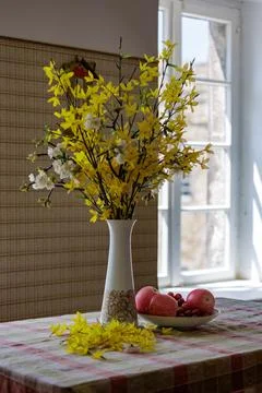Spring flower bouquet on rustic table beside bright window in vintage home. Fotos Stock