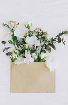 Spring flowers in envelope flat lay. Roses, hydrangea, and eucalyptus  grow.. Stock Photos