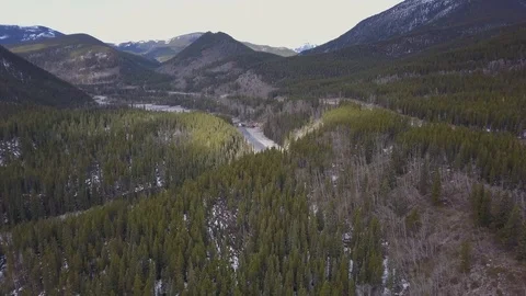 Spring flyover of boreal river canyon with mountains in the background Stock Footage 107985720