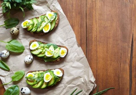 Spring food. A whole grain bread toast sandwich with avocado, spinach, guacamole Stock Photos