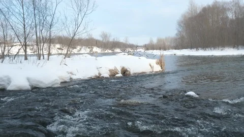 Spring forest river. Melting ice on the river, white snow on the river banks Stock Footage 125298695