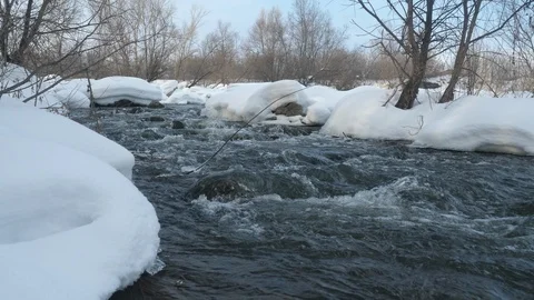 Spring forest river. Melting ice on the river, white snow on the river banks Stock Footage 125299762