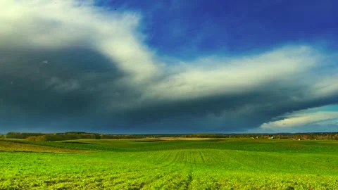 Spring green field under thunderstorm clouds in 4k time lapse. Stock Footage 154721200