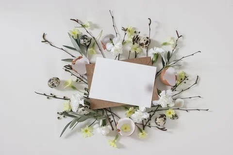 Spring greeting card, Easter invitation mockup. Primrose, white carnation Fotos de archivo