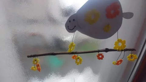 Spring Hanging Decoration with a Sheep and Colorful Flowers on a Window Stock Footage 333642294