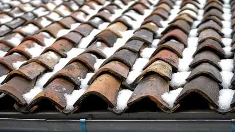 Spring has come, snow is melting, water is flowing from the tiled roof Stock Footage 124687391