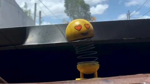 Spring head car toy bouncing on old car dashboard Stock Footage 310346594