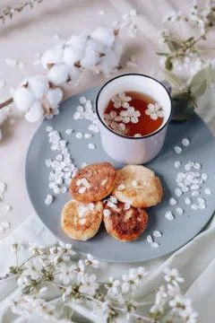 Spring healthy Breakfast fried cheesecakes, against a blooming bouquet flower Stockfoto's