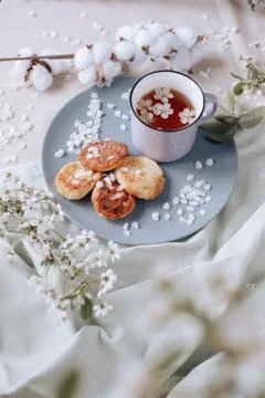 Spring healthy Breakfast fried cheesecakes, against a blooming bouquet flower Stock Photos