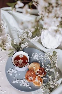 Spring healthy Breakfast fried cheesecakes, against a blooming bouquet flower Stock Photos