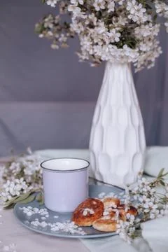 Spring healthy Breakfast fried cheesecakes, against a blooming bouquet flower Stock Photos