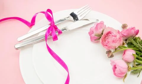 Spring Holiday table setting, Pink buttercup flowers and cutlery on white pla 写真素材