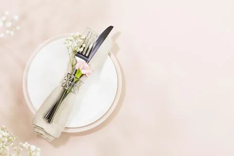 Spring holiday table settings on light pink background with spring white flow Foto stock