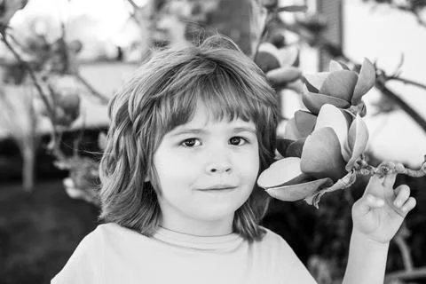Spring kid with flower tree. Cute child in blossom garden. Happy boy at park Fotos Stock