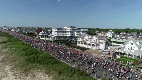 THE SPRING LAKE FIVE MILE RUN - RUNNERS HEAD OUT ON ROAD ADJACENT TO BEACH. Video stock 242304073