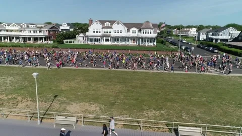 THE SPRING LAKE FIVE MILE RUN - FROM LAST OF RUNNERS TO BEACH. Stock Footage 242304156