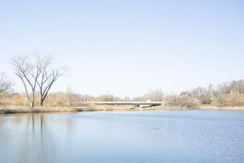 Spring landscape of the blue river with a bridge and trees.  Stock Photos