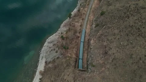 A spring landscape of Lake Baikal with a view of clearwater and a railway Stock Footage 311851229