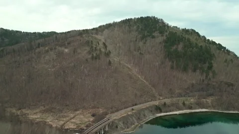 A spring landscape of Lake Baikal with a view of clearwater and a railway Stock Footage 311851676