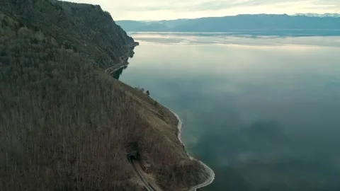 A spring landscape of Lake Baikal with a view of clearwater and a railway Stock Footage 311851797