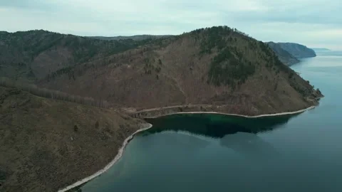 A spring landscape of Lake Baikal with a view of clearwater and a railway Stock Footage 311853393