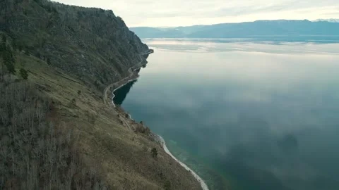 A spring landscape of Lake Baikal with a view of clearwater and a railway Stock Footage 311853417