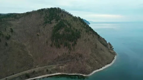 A spring landscape of Lake Baikal with a view of clearwater and a railway Stock Footage 311853525
